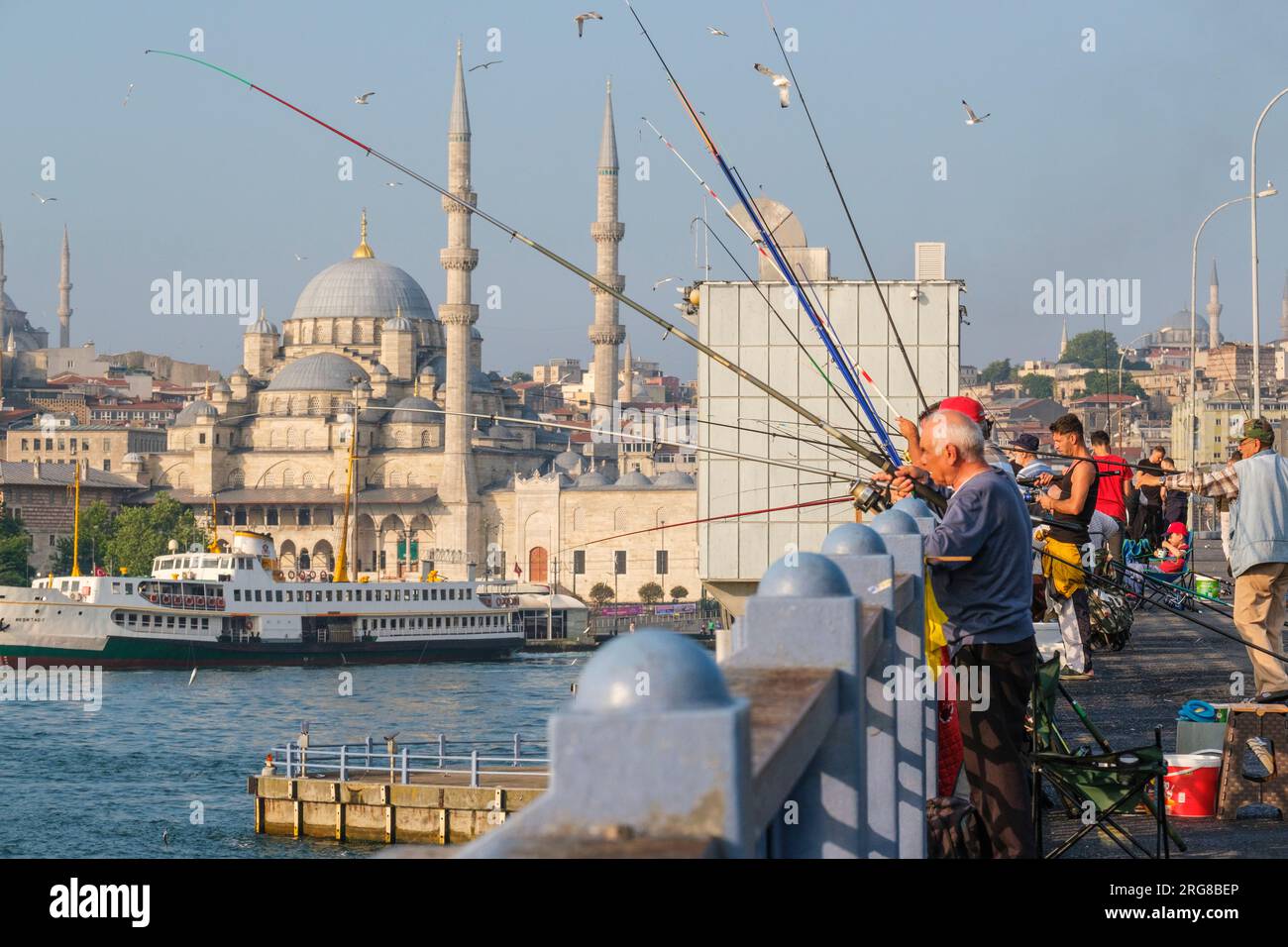Istanbul, Turchia, Türkiye. Pescatori sul ponte Galata. La nuova Moschea (Yeni Camii, completata nel 1663) in background a sinistra. Foto Stock