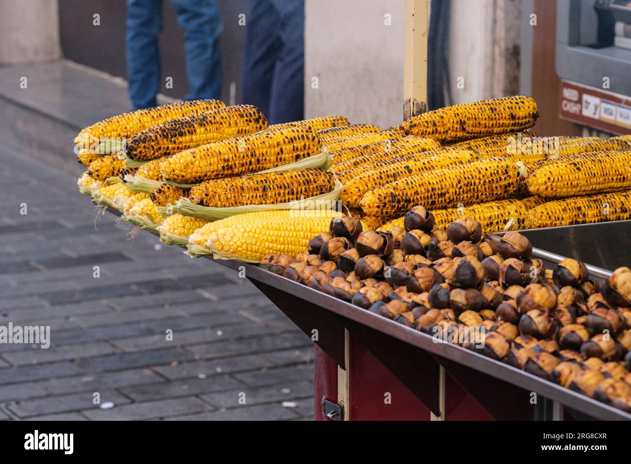 Istanbul, Turchia, Türkiye. Istiklal Street, venditore di mais arrosto sul pannocchie e castagne. Foto Stock