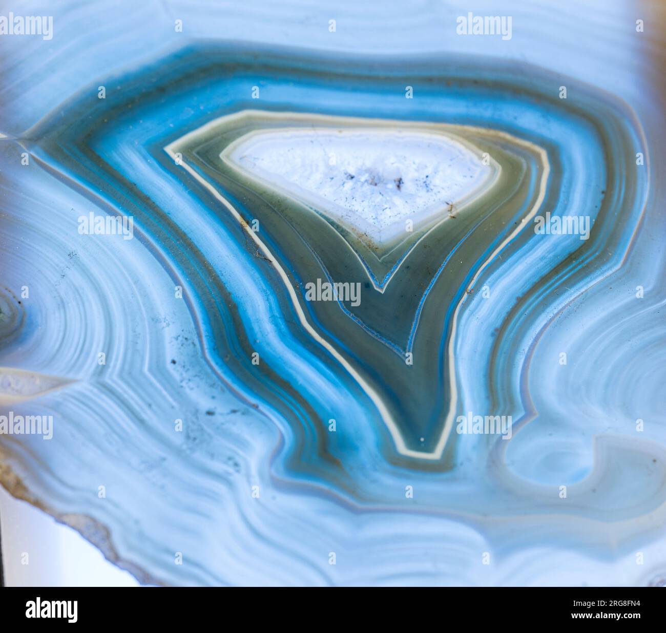 Sottile fetta di agata blu con cristalli in geode, illuminata da dietro Foto Stock