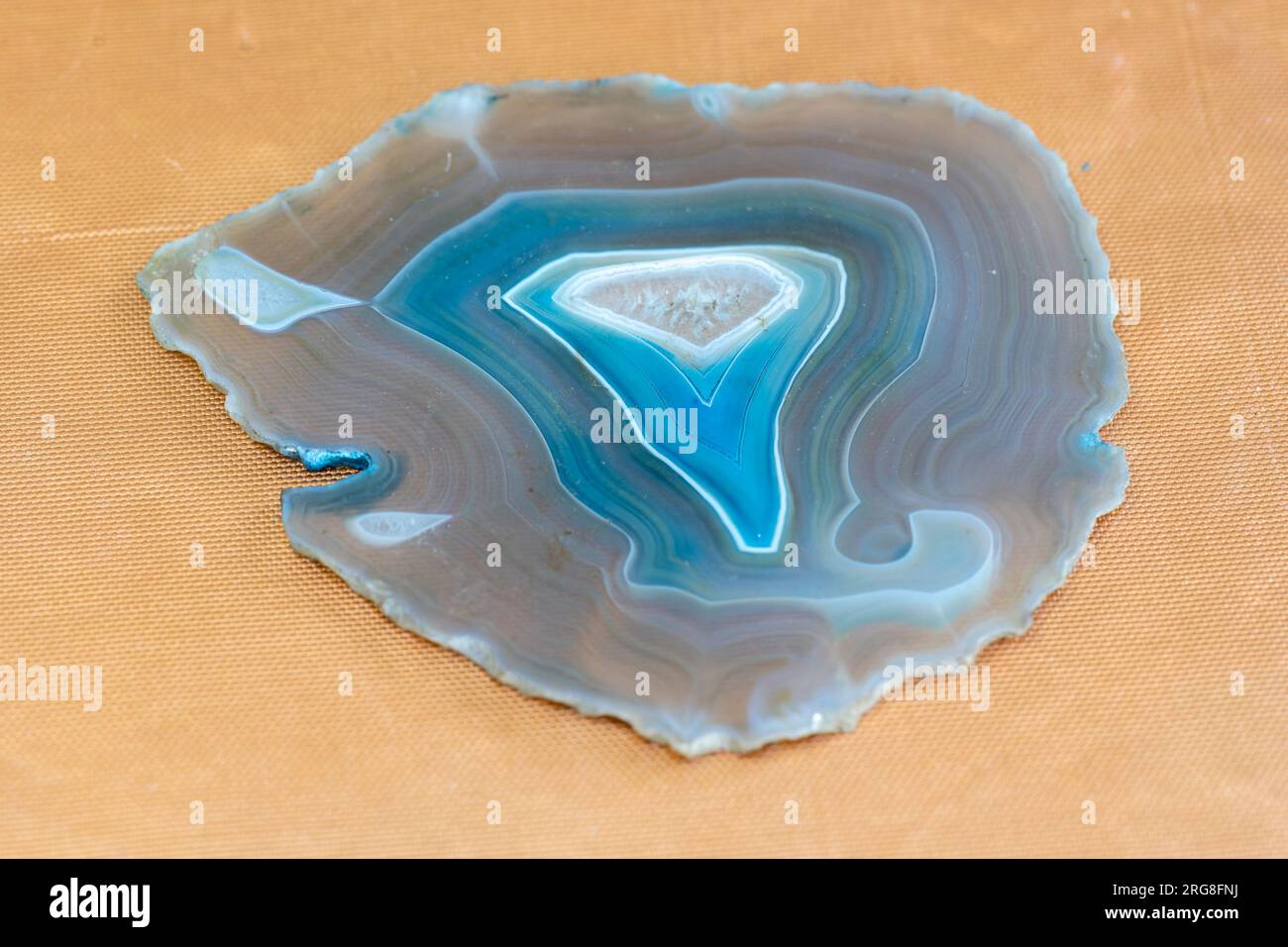 Sottile fetta di agata blu con cristalli in geode, illuminata da dietro Foto Stock
