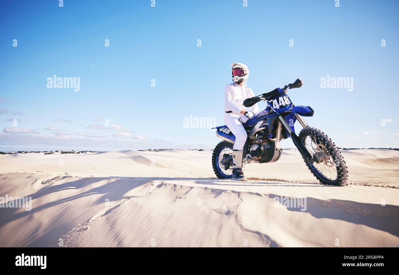 Sabbia, sport motoristici e uomo con moto per adrenalina, avventura e libertà nel deserto. Azione, sfida estrema e persona maschile in bicicletta sulle dune Foto Stock
