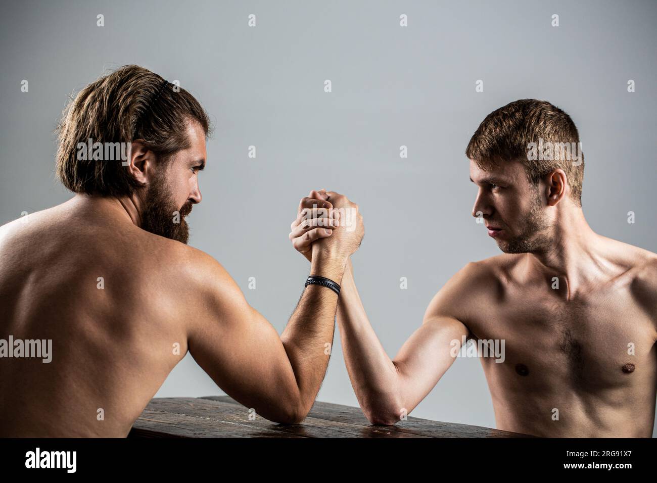 Armi che lottano mano sottile, grande braccio forte in studio. Due mani di uomo hanno stretto il braccio wrestling, forte e debole, corrispondenza disuguale. Braccio wrestling. Pesantemente Foto Stock
