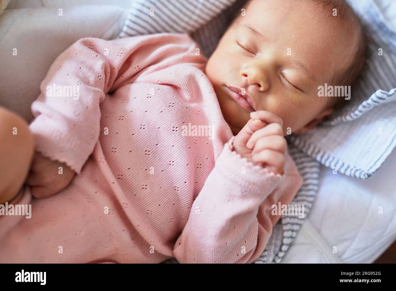 Neonata che dorme tranquillamente nella culla Foto Stock