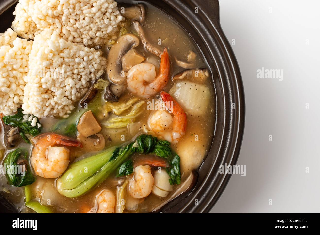 Zuppa di riso glutinosa fritta con frutti di mare su sfondo bianco Foto Stock