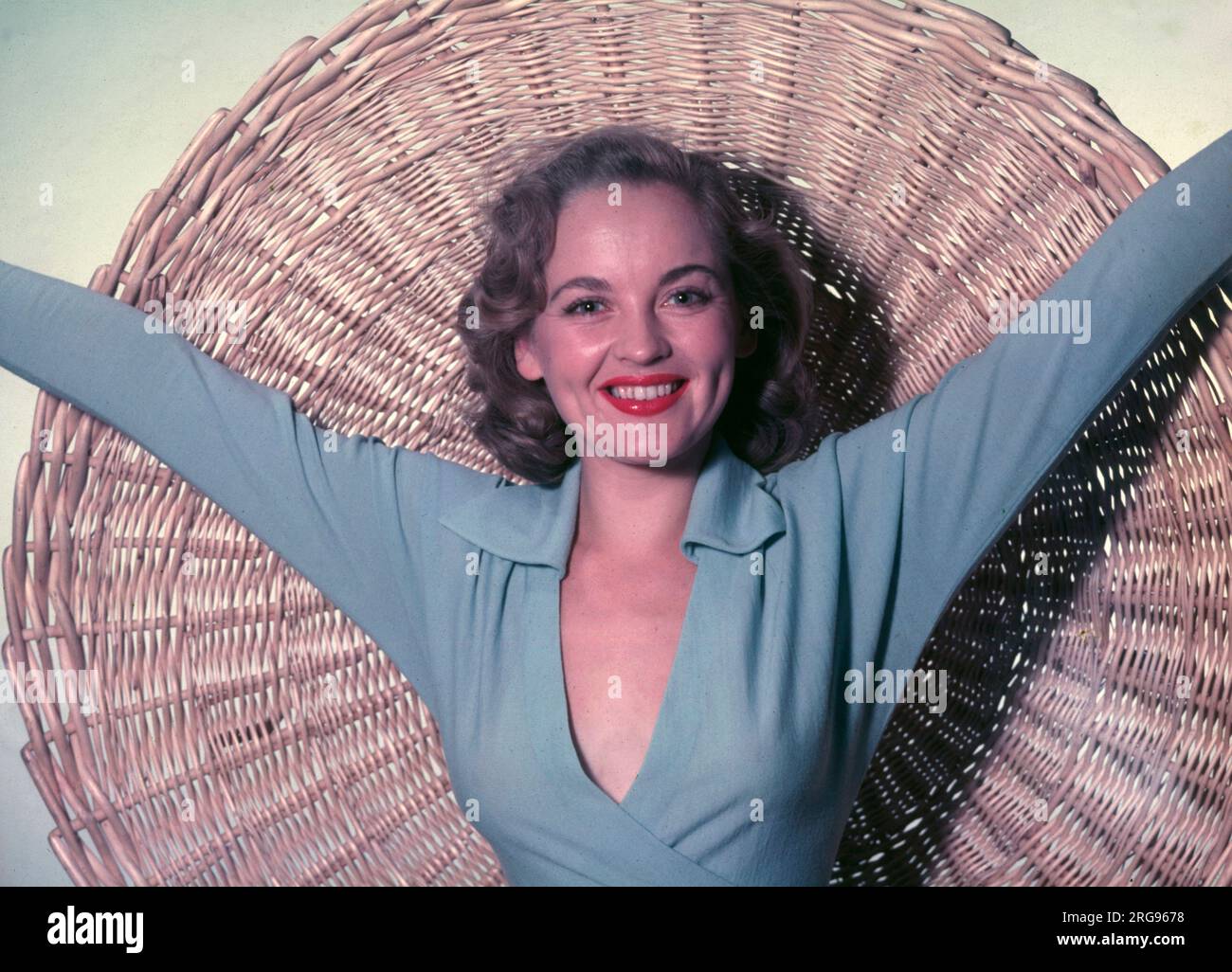 Modello femminile in un top blu pallido con sfondo in muratura. Foto Stock