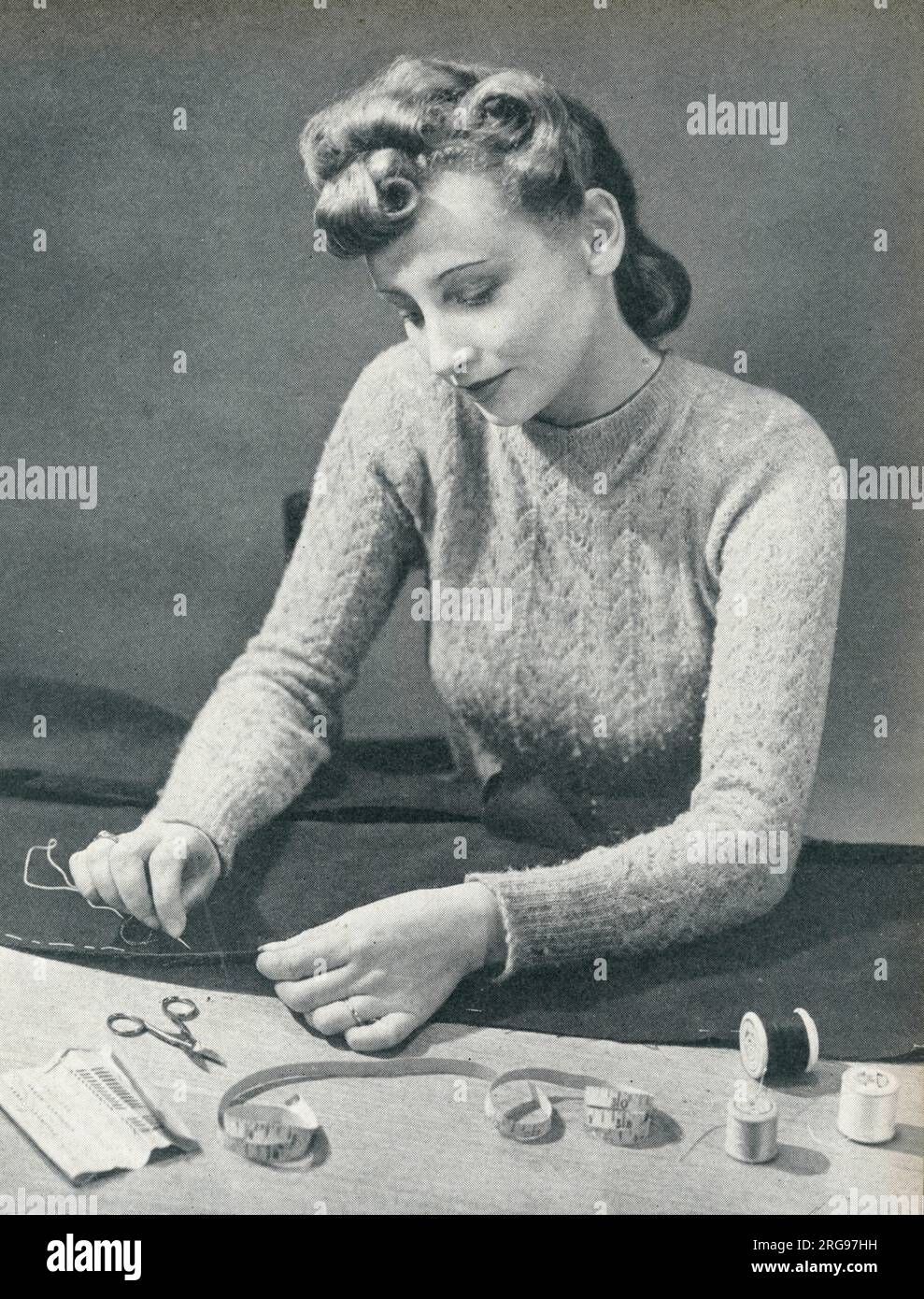 Donna che indossa un orlo in cotone prima di cucirlo. Foto Stock