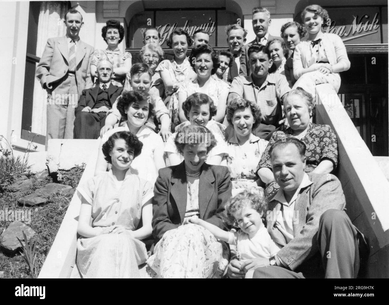 Un gruppo di villeggianti posa per una foto allegra all'esterno della pensione Gladsmuir, in Palace Road, Douglas, Isola di Man. Foto Stock