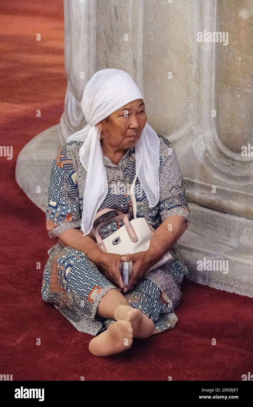 Istanbul, Turchia, Türkiye. Donna che indossa un Hijab riposa nella Moschea Blu (Moschea del Sultano Ahmed) Foto Stock