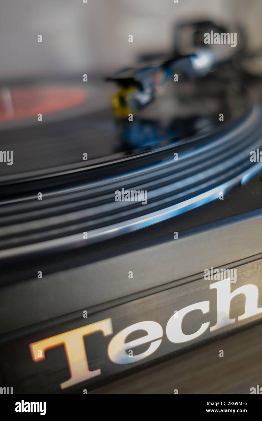 Primo piano in vinile con registrazione che gira su Technics 1210 MK2 DJ Deck giradischi con sfocatura del movimento. Foto Stock