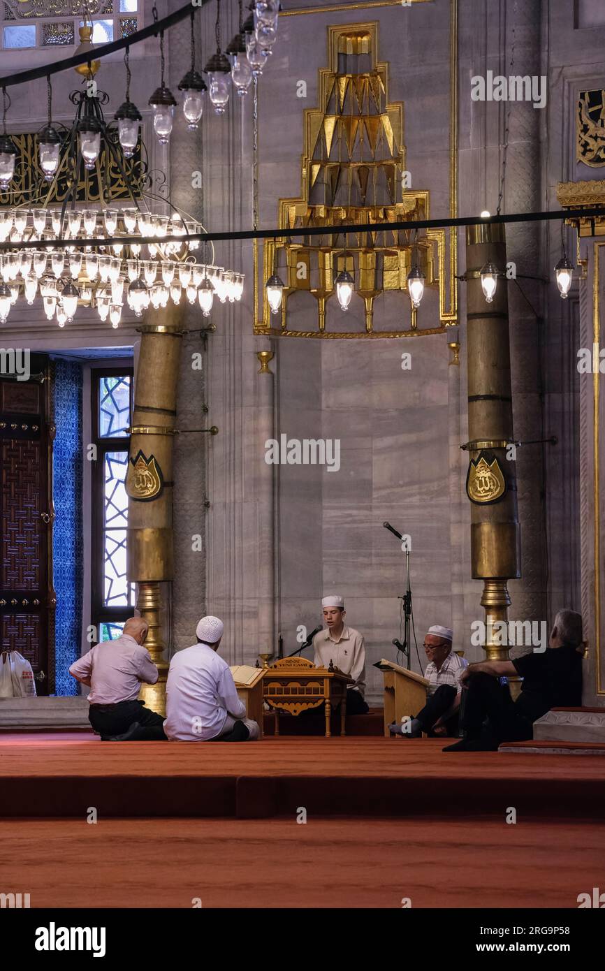 Istanbul, Turchia, Türkiye. Nuova Moschea (Yeni Camii). Imam recita dal Corano prima delle preghiere. Foto Stock