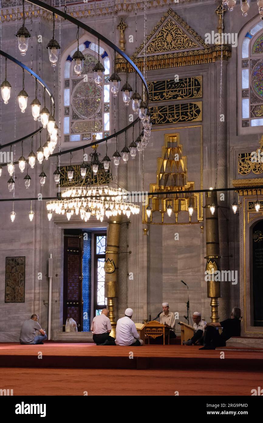 Istanbul, Turchia, Türkiye. Nuova Moschea (Yeni Camii). Imam recita dal Corano prima delle preghiere. Foto Stock