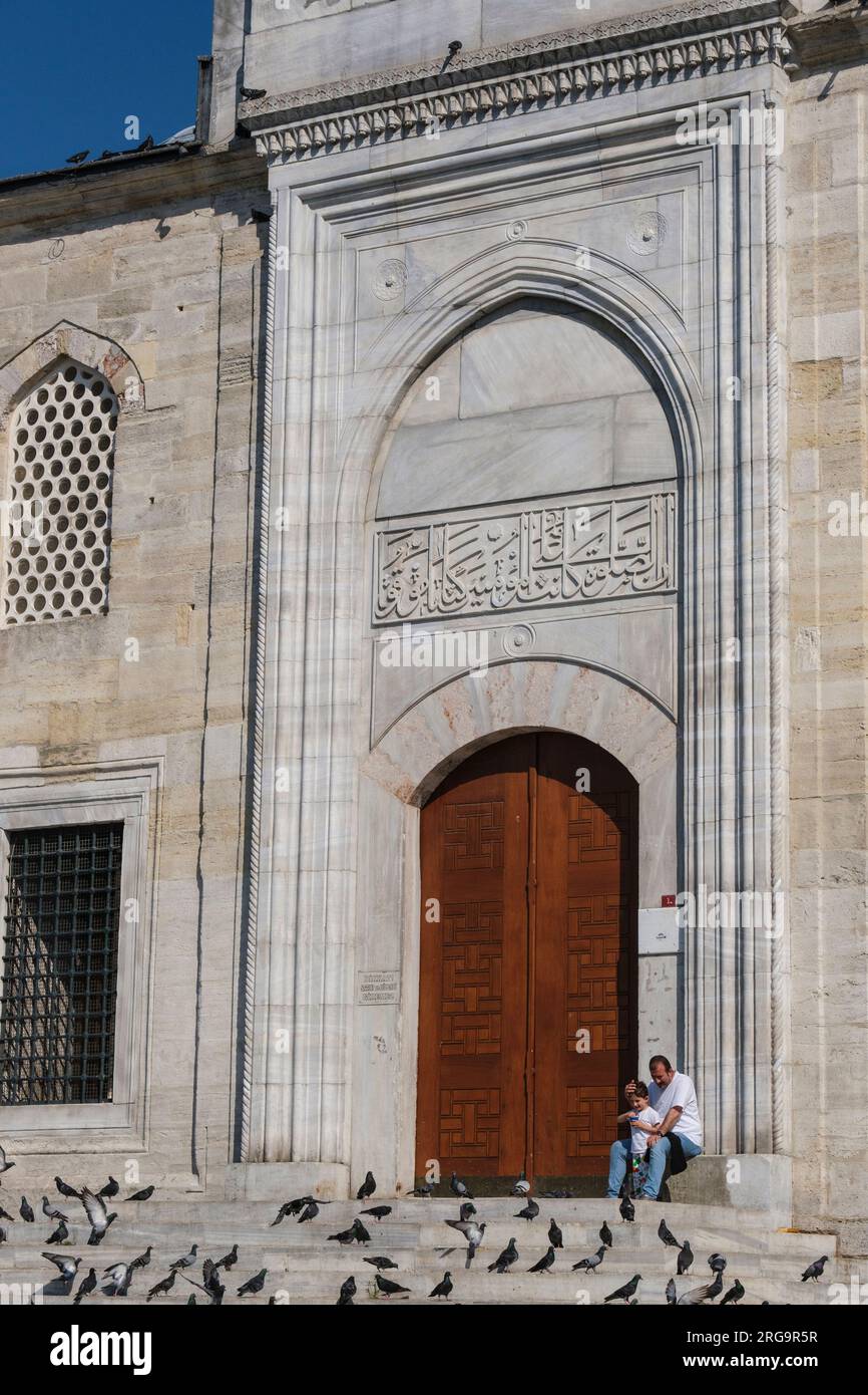 Istanbul, Turchia, Türkiye. Padre e figlio fuori dalla nuova Moschea (Yeni Camii), con i piccioni. Foto Stock