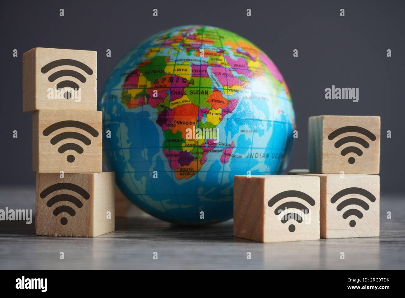 Immagine ravvicinata del globo e dei cubi di legno con icona wifi. Internet e concetto di rete globale Foto Stock