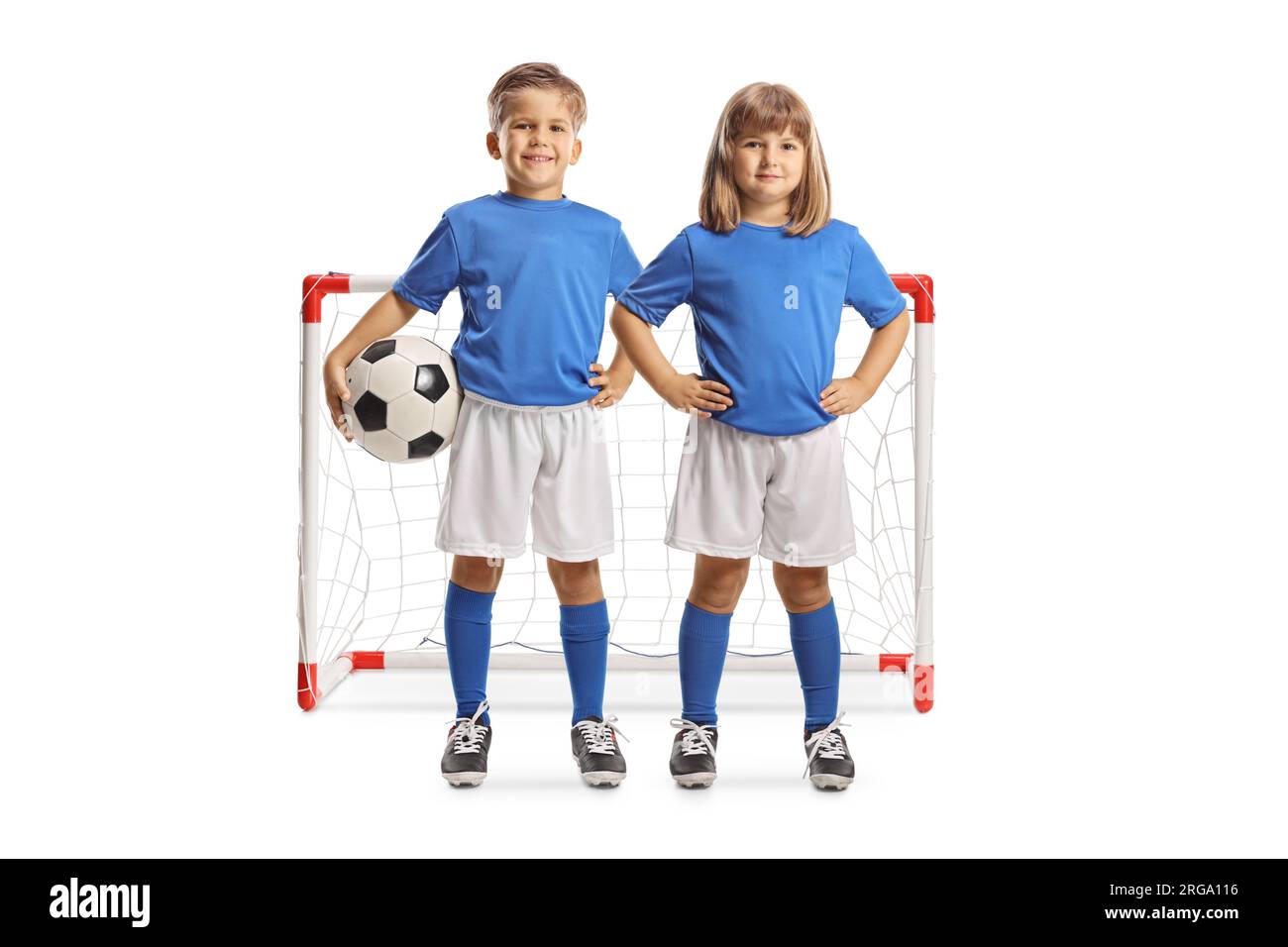 Ragazza e ragazzo con maglie da calcio in posa con una palla davanti a un gol isolato su sfondo bianco Foto Stock