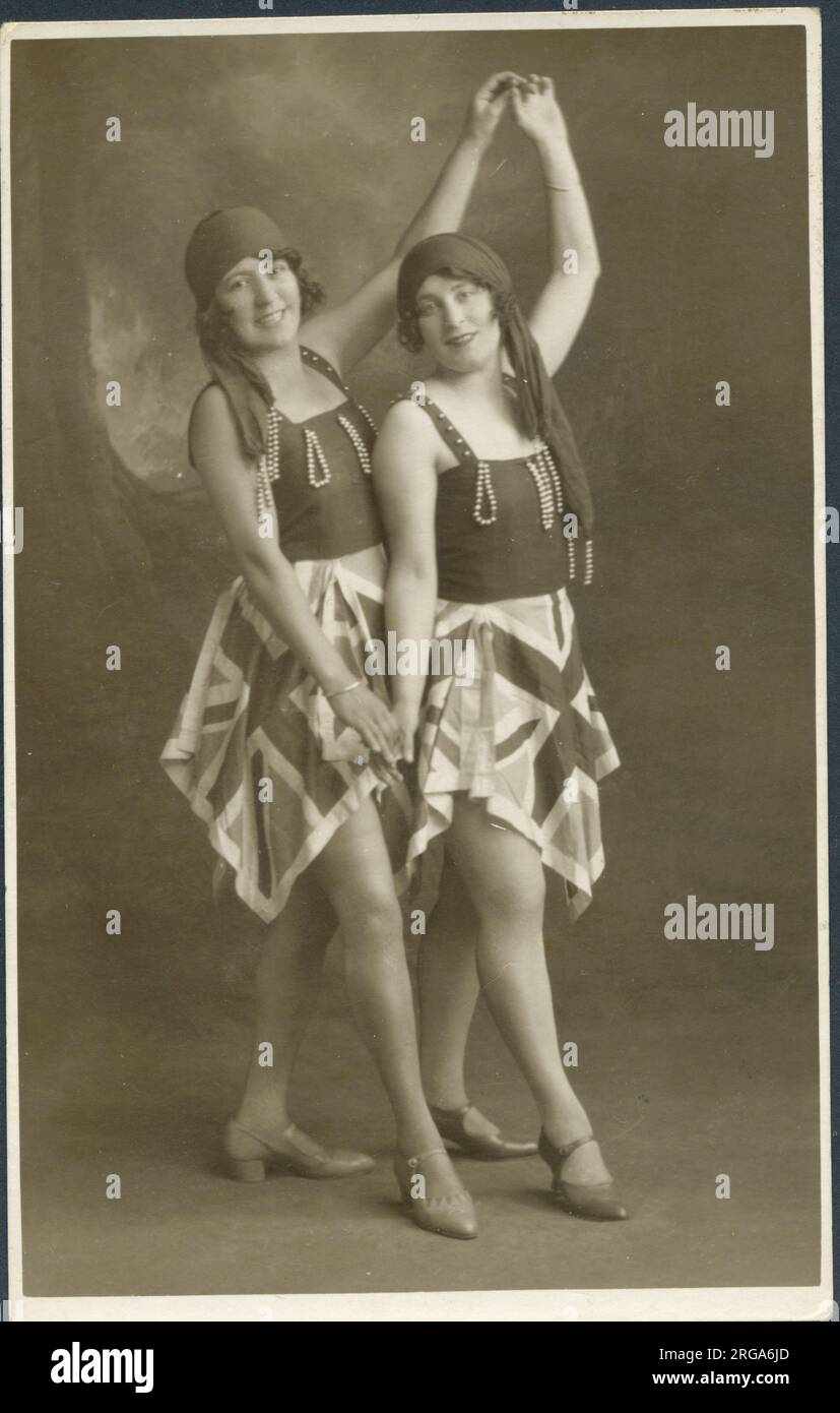 Due donne posano per una fotografia con costumi identici, dato il fascino patriottico delle gonne Union Jack. Foto Stock