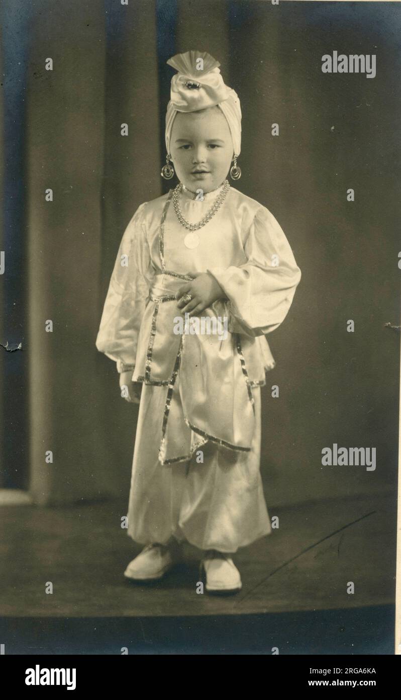 Un bambino (o una ragazza) vestito con un turbante e pantaloni harem in un elegante abito stile Arabian Nights. Foto Stock