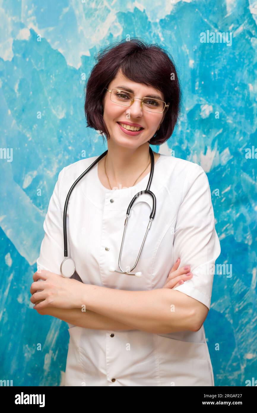 Gli allegri occhiali da infermiera si trovano vicino a un muro blu. Foto Stock