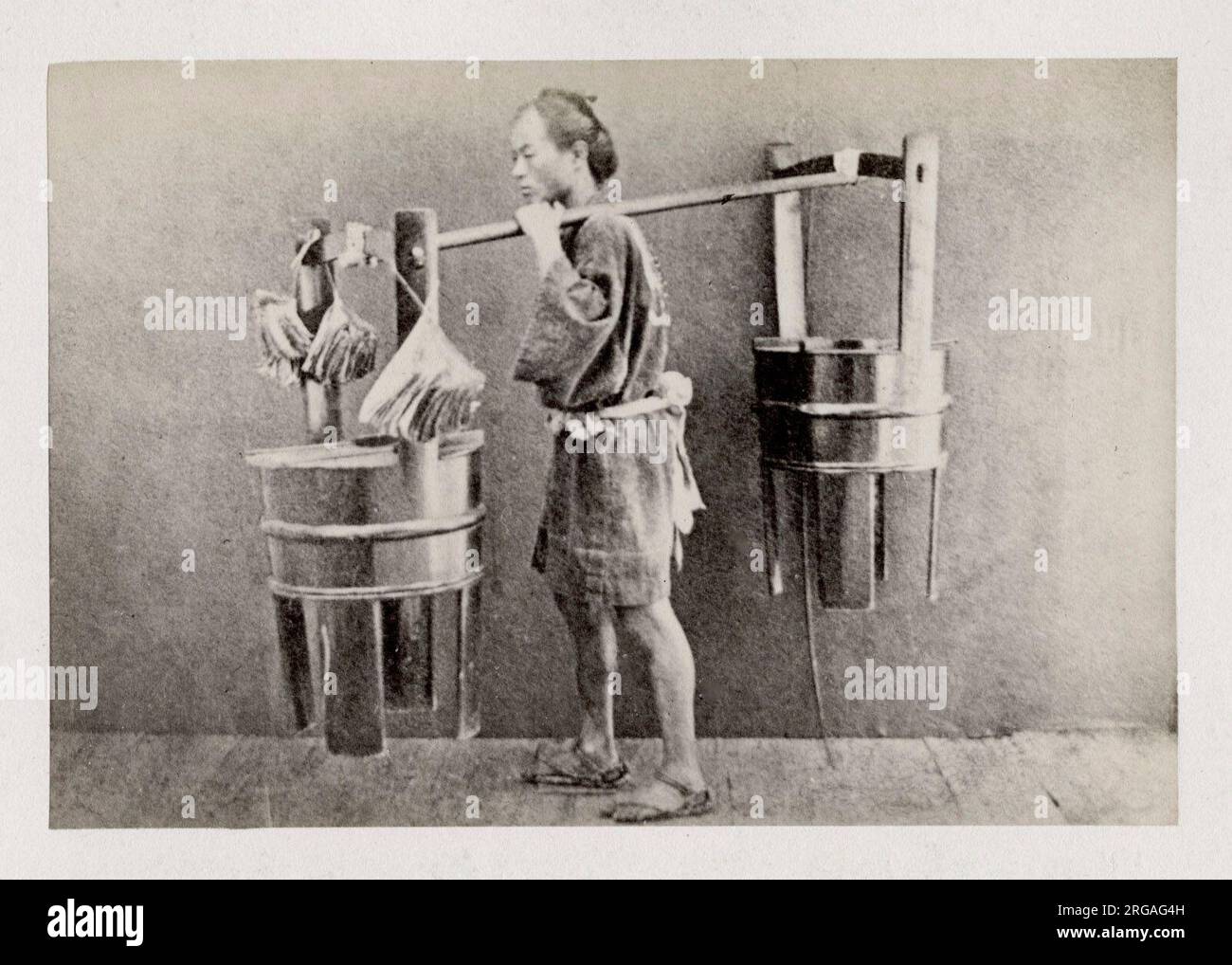 Fotografia d'epoca del XIX secolo - ritratto fotografico di origini giapponesi, probabilmente opera del fotografo giapponese Shimooka Renjo - portatore o venditore che trasporta un carico. Foto Stock