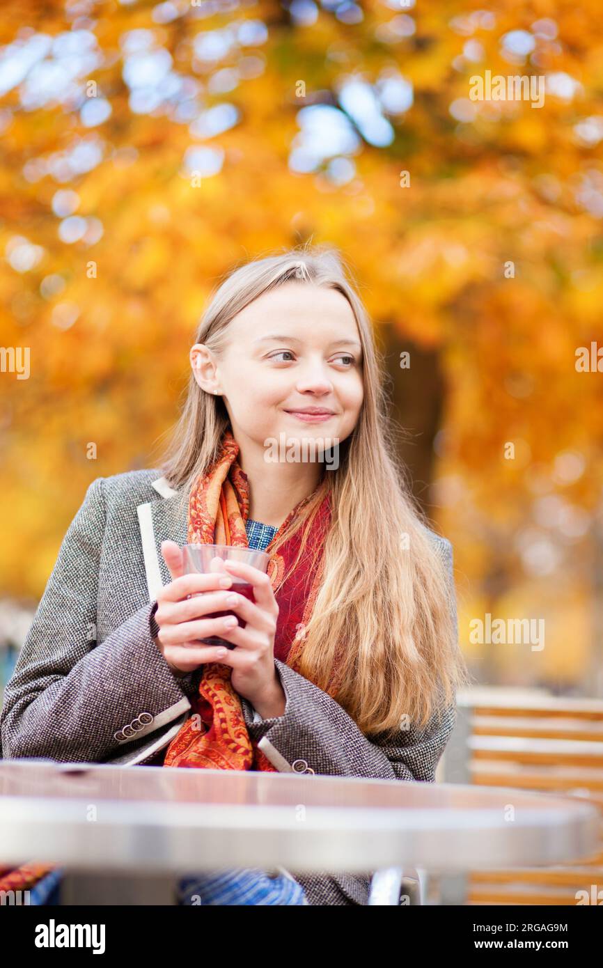 Ragazza che beve vino caldo in un caffè Foto Stock