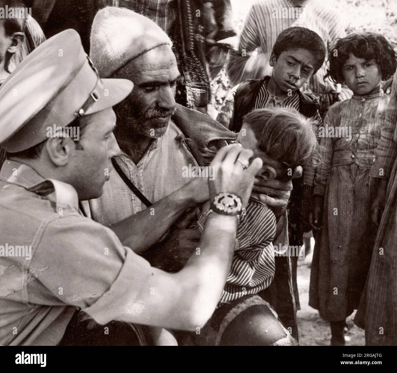 1943 Siria - l'ufficio militare britannico tratta i curdi lungo il confine con la Siria Turchia - molti soffrono di Trachoma fotografia di un ufficiale di reclutamento dell'esercito britannico di stanza in Africa orientale e in Medio Oriente durante la seconda guerra mondiale Foto Stock