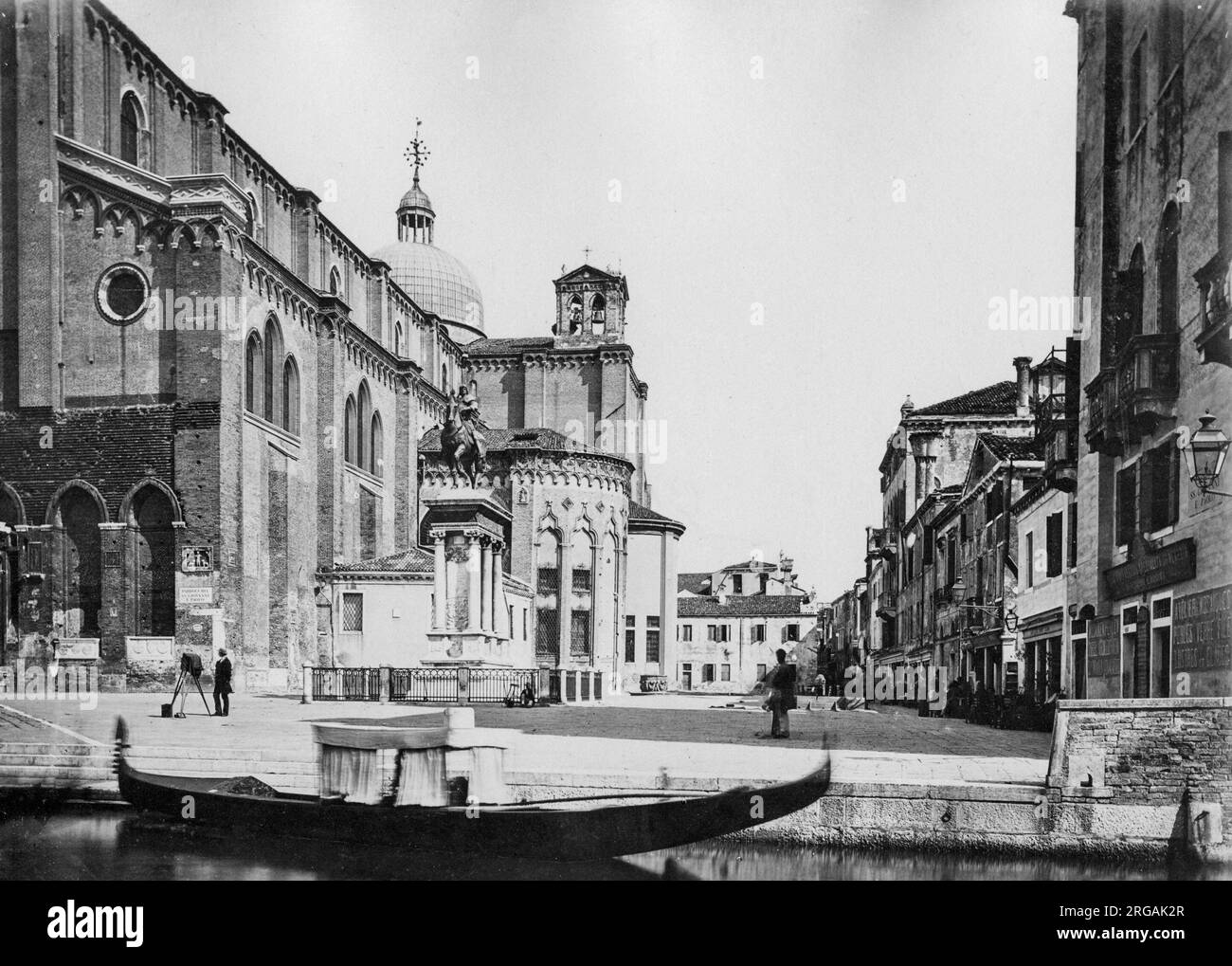 Fotografia d'epoca del XIX secolo - gondola, riva del canale e architettura cittadina, Venezia Italia, circa 1880s. Nota fotografo con fotocamera in basso a sinistra. Foto Stock