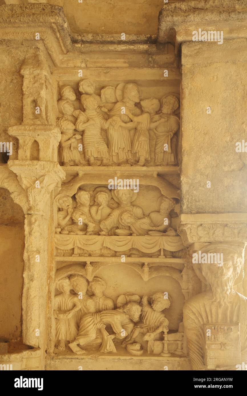 Scene bibliche con l'ultima cena, il lavaggio dei piedi e il bacio di Giuda nei chiostri del monastero romanico di Cloître St-Trophime, AR Foto Stock
