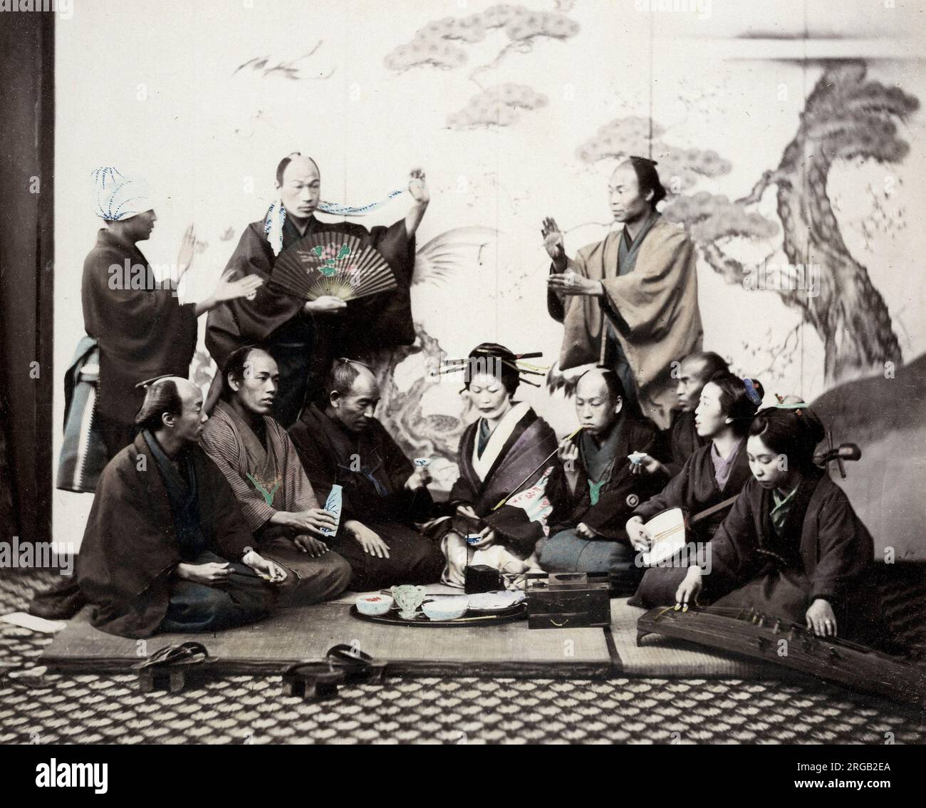 Giappone del 1860 - ritratto di un gruppo di uomini e donne che si gustano una cena sociale con musica danzante e sake Felix Beato (1832 - 29 gennaio 1909), fotografo italo-britannico che lavora principalmente in India, Giappone, Cina Foto Stock