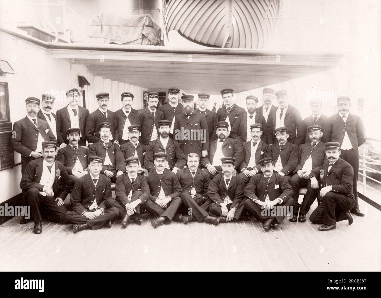 1889 fotografia - RMS Teutonico - da un album di immagini relative al lancio del vaso che è stato costruito da Harland e Wolff a Belfast per la White Star Line - in seguito per ottenere notorietà come il proprietario del Titanic. L'album mostra gli interni della nave, membro dell'equipaggio, crociere di prova, compresa una visita a bordo mediante il Kaiser tedesco e il Principe di Galles, così come molte immagini di altri visitatori. Questa immagine - chief steward e assistenti Foto Stock