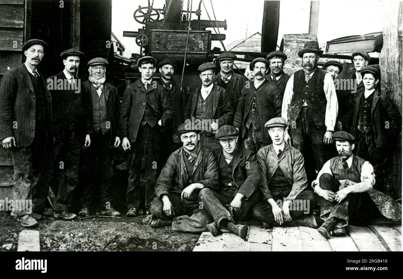 Draycott, villaggio di Cotswold, Butler vide operai di Mills con un motore a trazione a vapore sullo sfondo. Foto Stock