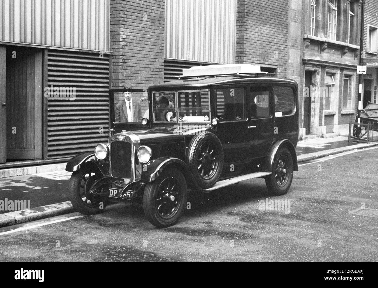 Austin 12/4 Heavy Saloon, regn. DP7657, da circa 1934, in una strada laterale di Londra. Foto Stock