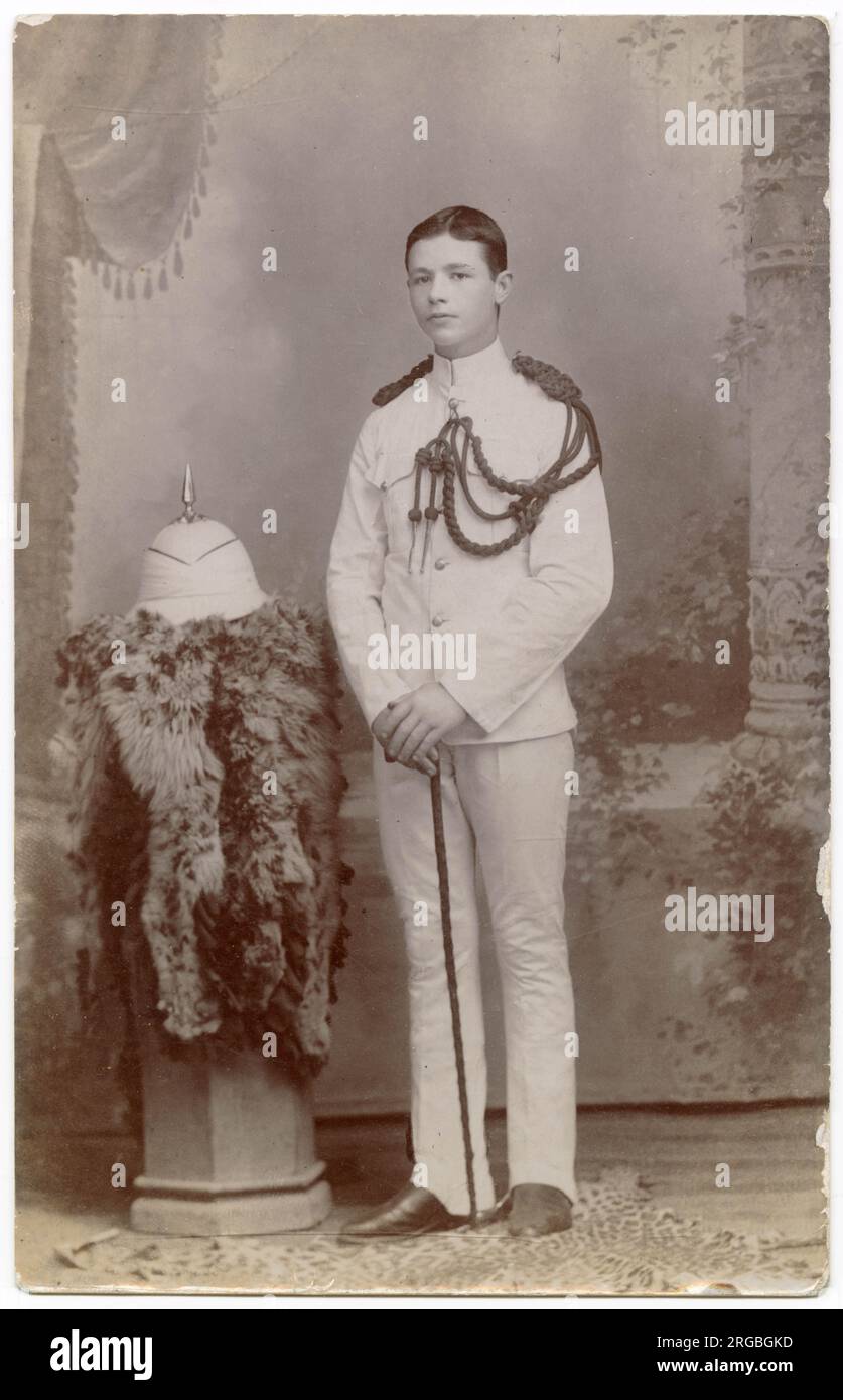 Foto in studio, giovane soldato in uniforme bianca, aiguillette con spalla sinistra e casco solare bianco a spillo, Estremo Oriente Foto Stock