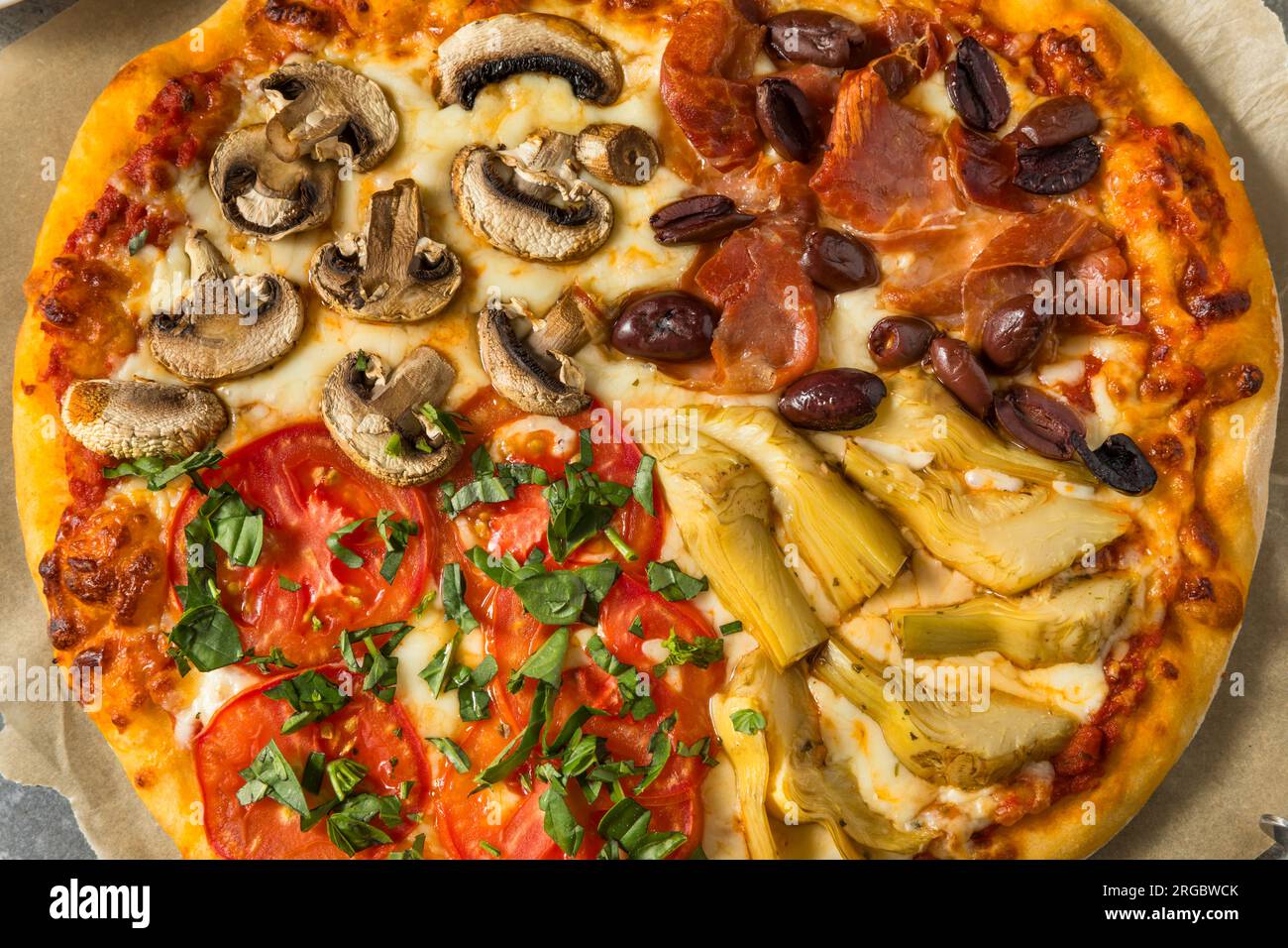 Pizza italiana Four Seasons con pomodoro olive funghi e carciofi Foto Stock