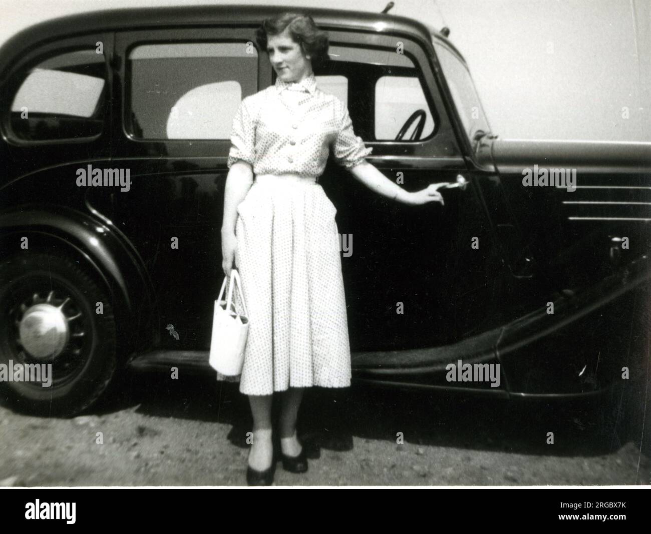 Giovane donna in piedi in macchina Foto Stock