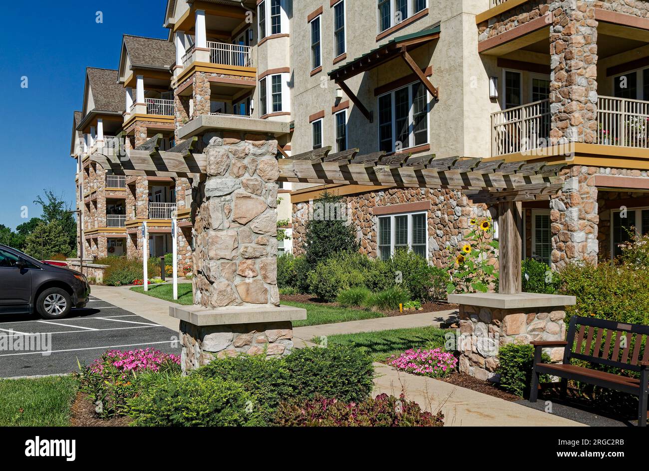 moderno edificio di appartamenti a 4 piani, in pietra, stucco, balconi, auto parcheggiate, giardini, bella giornata di sole, Pennsylvania, estate Foto Stock