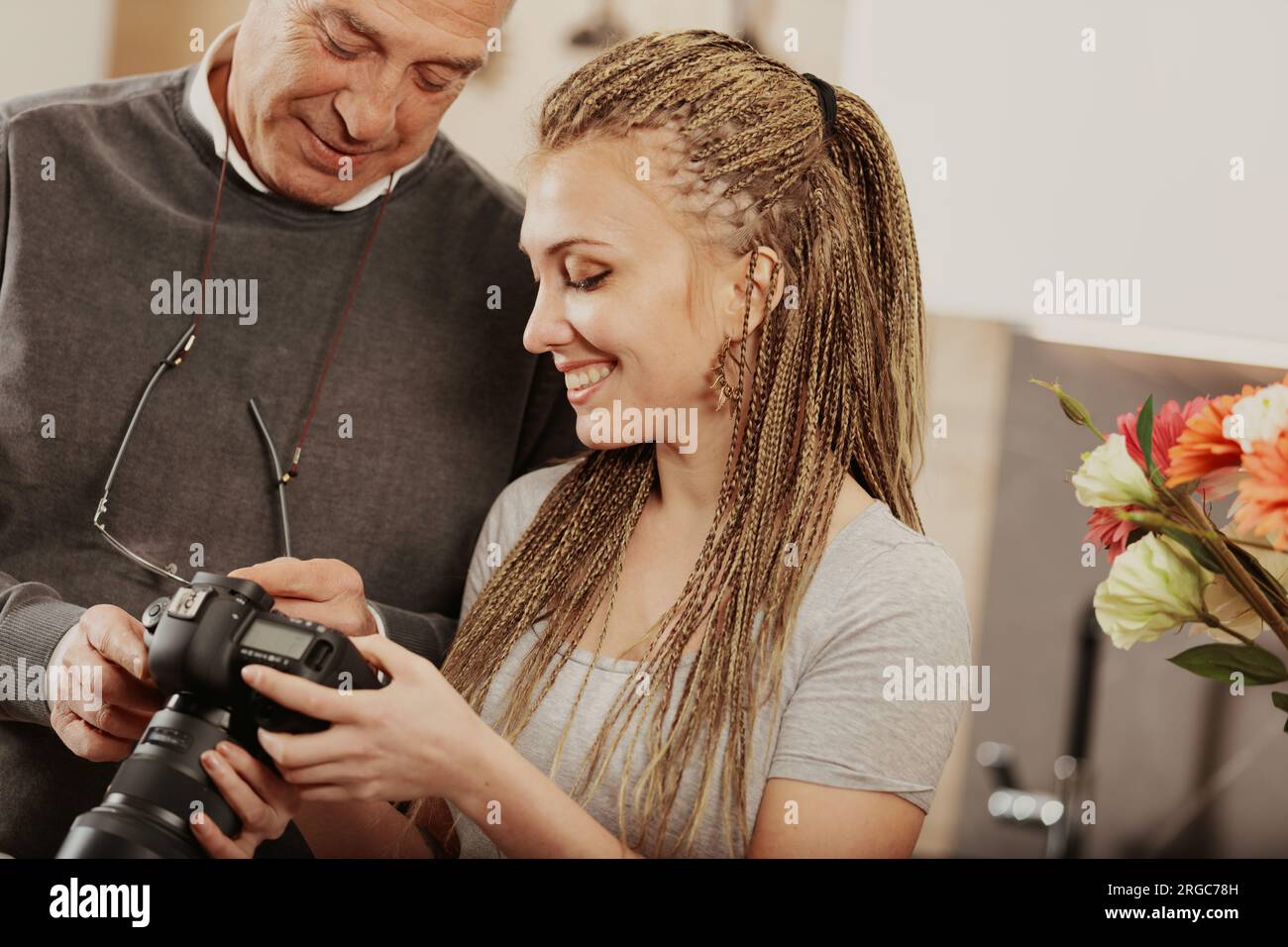 In cucina, un padre orgoglioso sorride alle foto di sua figlia. E' un'artista, felice del suo lavoro per la famiglia e la passione Foto Stock