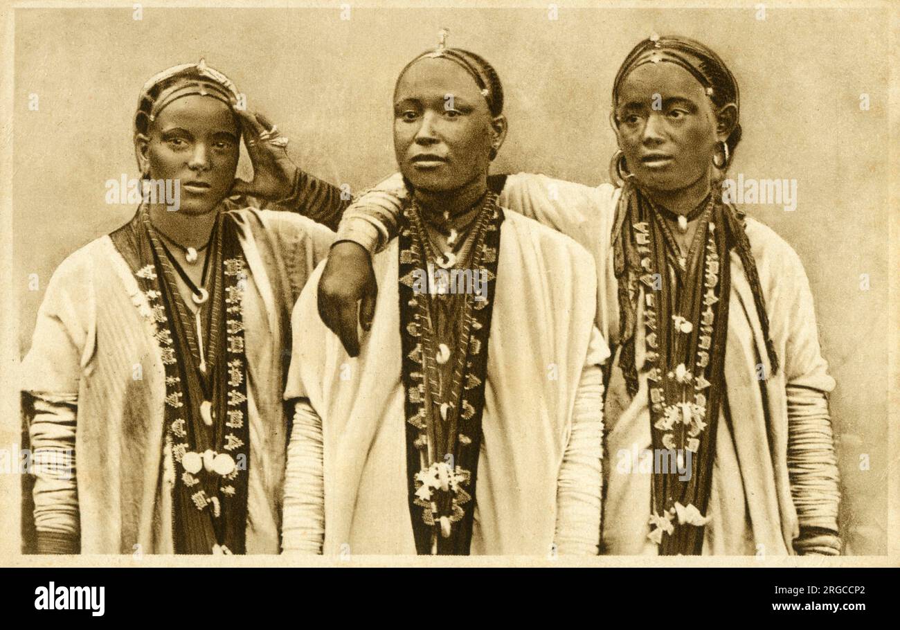 Tre bellissime giovani donne dell'Africa orientale adornate con lunghe collane, capelli intrecciati e una varietà di gioielli. Foto Stock