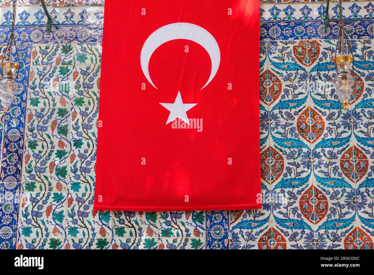Istanbul, Turchia, Türkiye. Piastrelle di Iznik e bandiera turca alla Moschea del Sultano Eyup, Foto Stock
