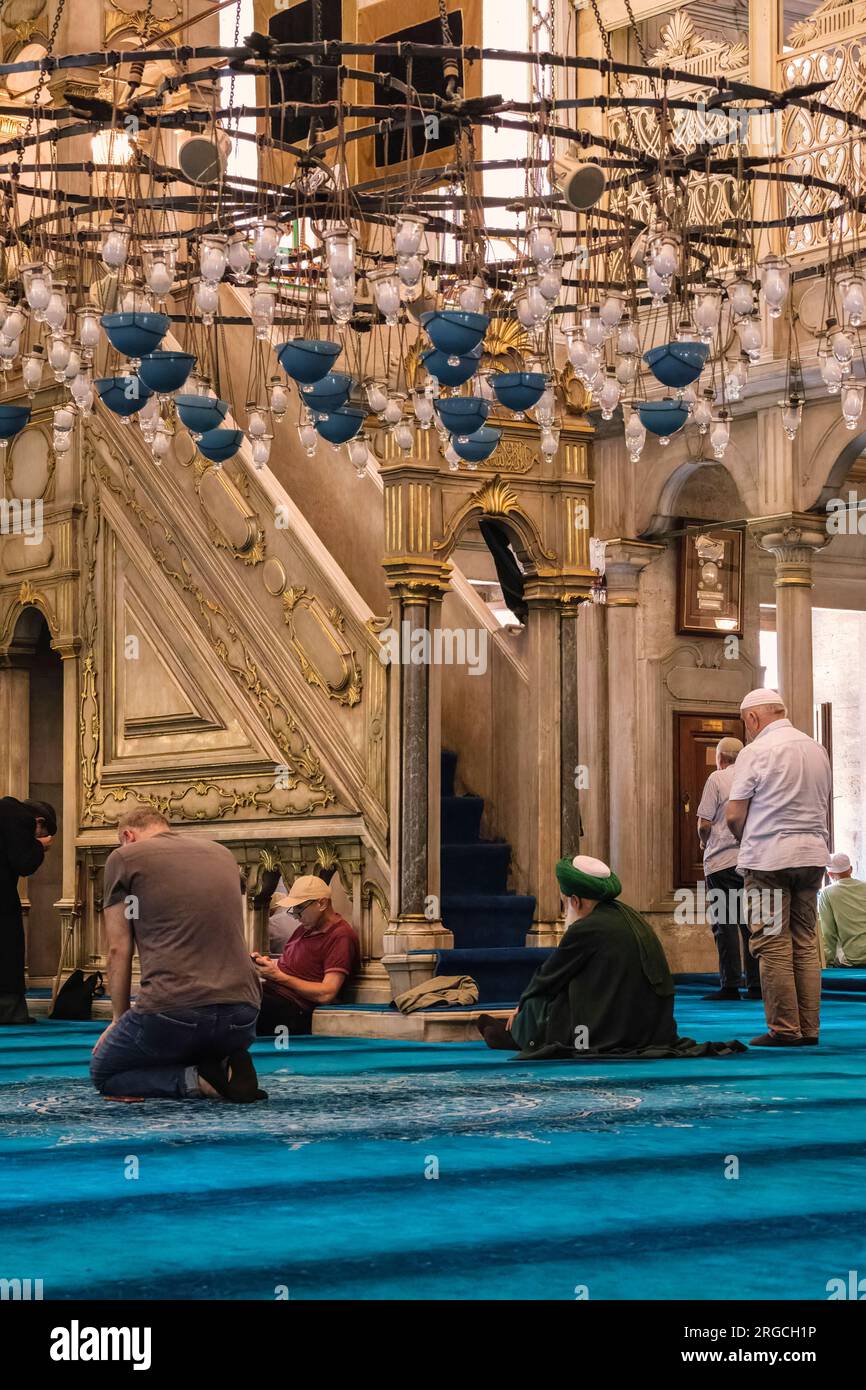 Istanbul, Turchia, Turkiye. Moschea del Sultano Eyup, uomini che pregano individualmente presso il Minbar in attesa della preghiera comune di mezzogiorno. Foto Stock