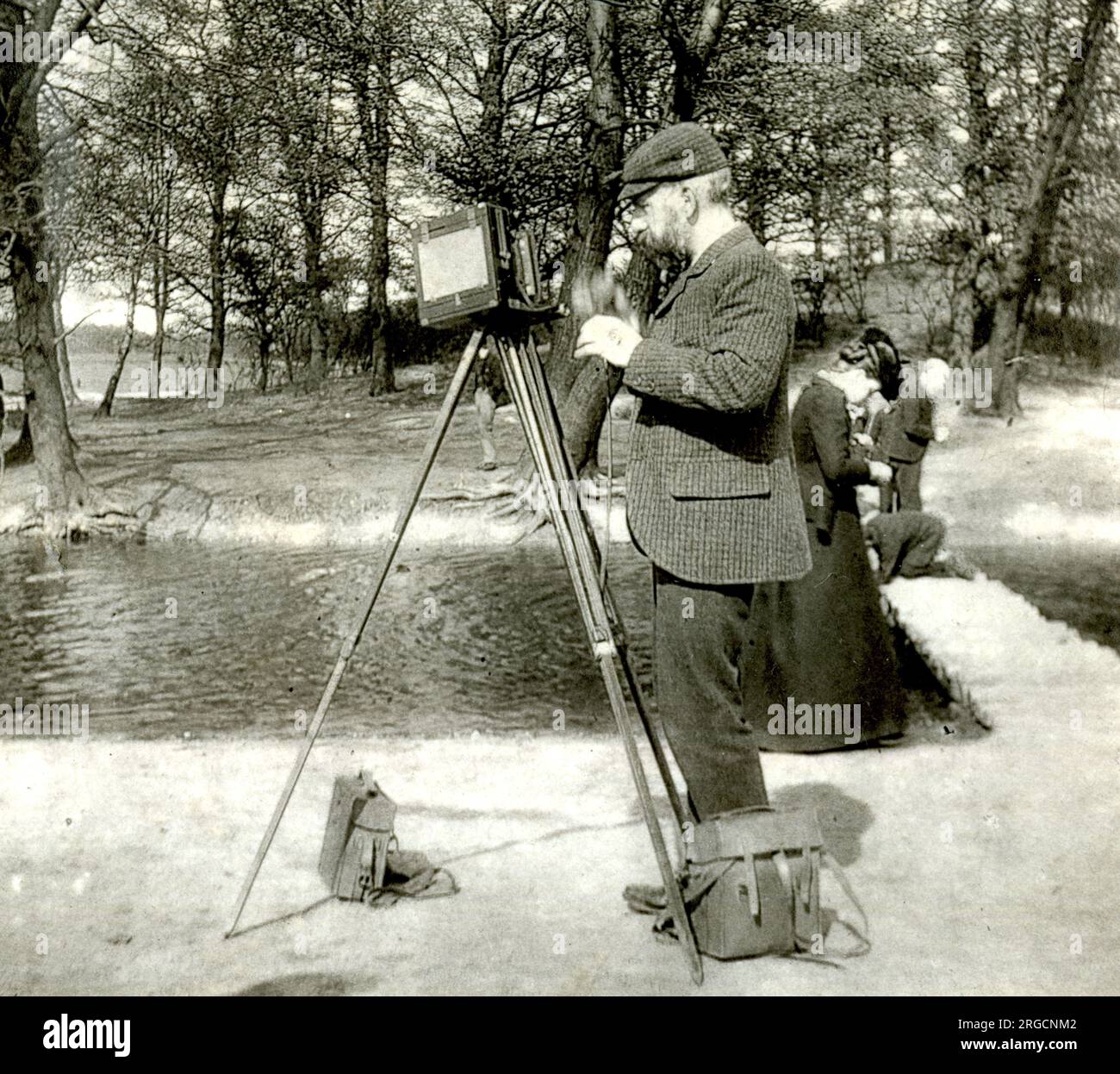 Fotografo in un parco con una macchina fotografica in legno su un cavalletto Foto Stock