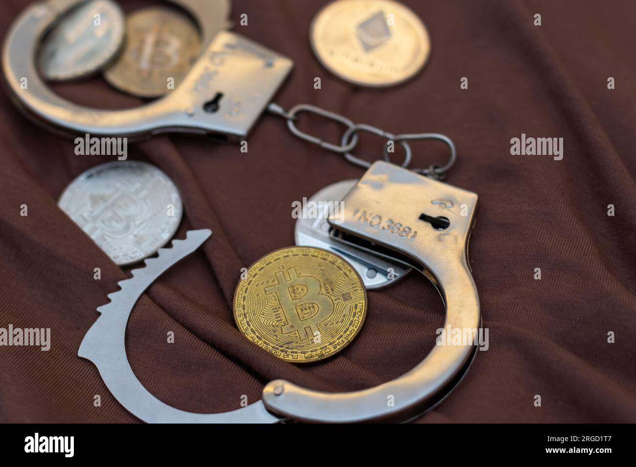 un bitcoin dorato sullo sfondo di manette e una tastiera nera per computer portatile. Divieto di vendita e acquisto di bitcoin e criptovalute. Foto Stock