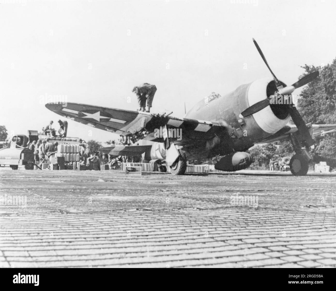 United States Air Force - Republic P-47C Thunderbolt in fase di rifornimento presso il punto di rifornimento di un Advanced Landing Ground in Francia, alla fine del 1944. (Notare il tracciamento di Sommerfeld, utilizzato per creare una classifica rigida degli aeromobili e piste di rullaggio nei siti green-Field). Foto Stock