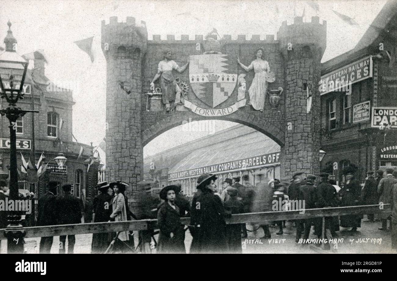 Visita reale a Birmingham - 7 luglio 1909 - arco a corona con 'avanti' sotto lo stemma - London & North Western Railway Company (L&NWR) Parcels Office e folla in attesa. Foto Stock