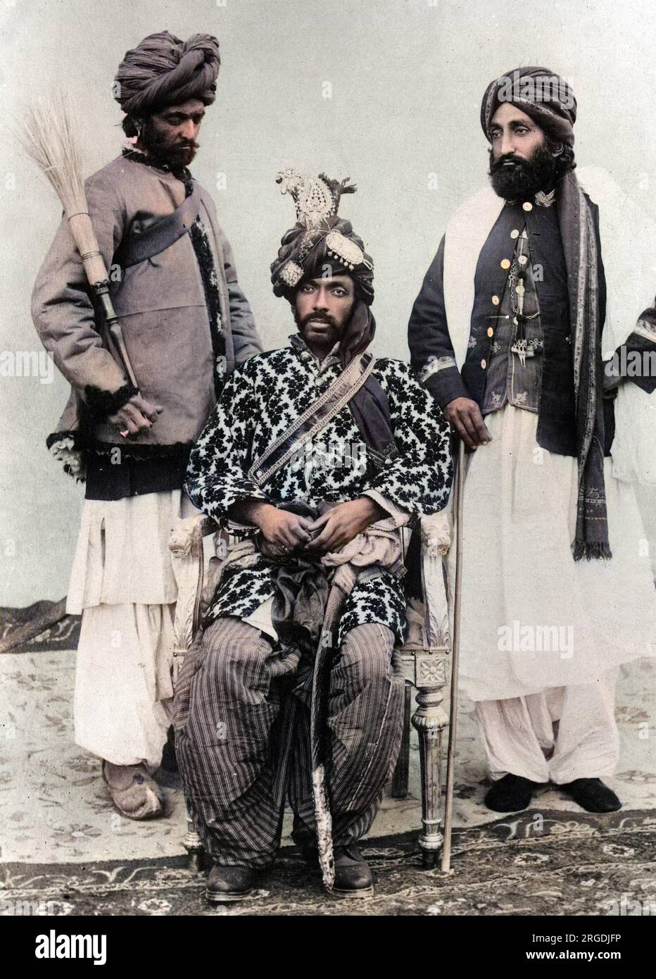Il Khan di Kalat, Mir Mahmood Khan (governato dal 1893 al 1931), sedette. Il Khan governò il Kalat, parte del Balochistan o del Baluchistan, ora parte del Pakistan. Un servo con una frusta di mosca lo assiste (a sinistra). Foto Stock