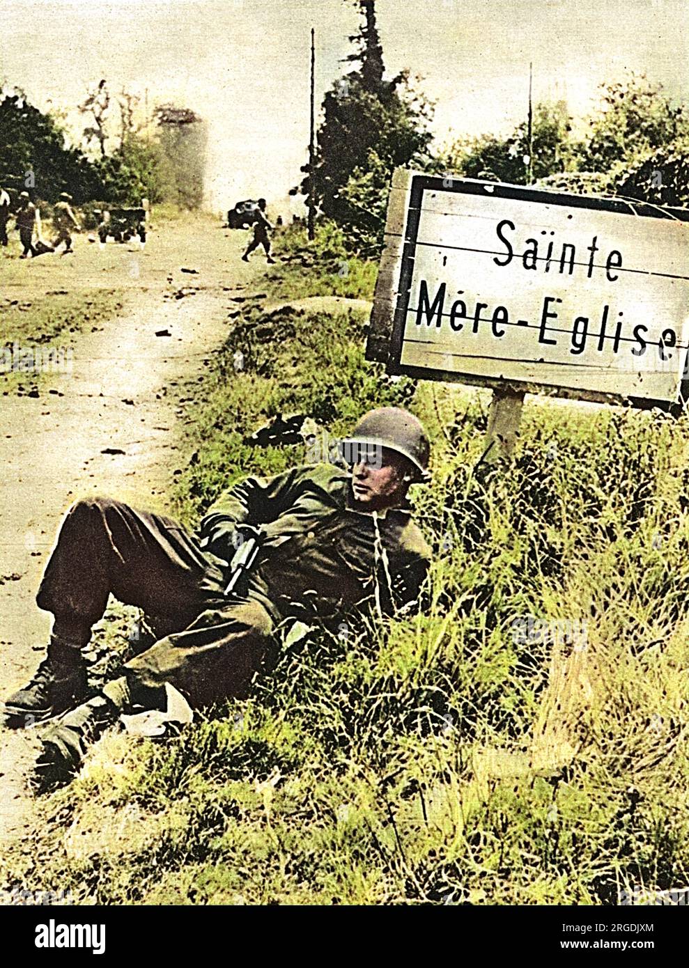 Un paracadutista americano che fa una breve sosta sulla strada a St Mere Eglise, Normandia. Questa città è stata catturata dalle truppe americane in volo poco dopo che sono atterrate il 'D-Day', 6th giugno 1944. Foto Stock