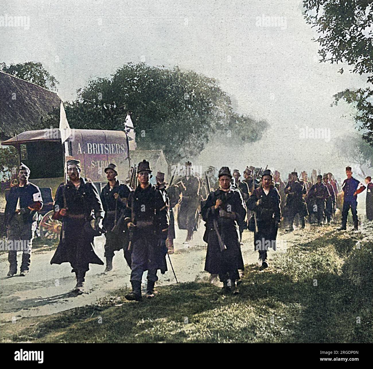 Soldati belgi sulla marcia nel villaggio di St Trond, nelle prime settimane della grande Guerra, diretti al fronte. All'estrema destra della foto c'è un prete che indossa un distintivo della Croce Rossa sul braccio. A sinistra c'è un carro di proprietà di un commerciante locale. Foto Stock