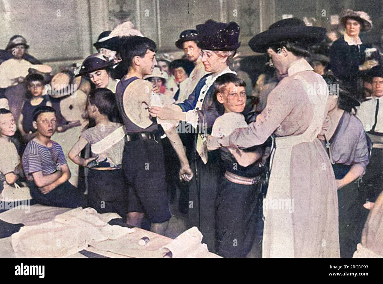 Infermiere volontarie che praticano le loro tecniche di fasciatura sui bambini al Kensington Town Hall poco dopo lo scoppio della prima guerra mondiale. Foto Stock