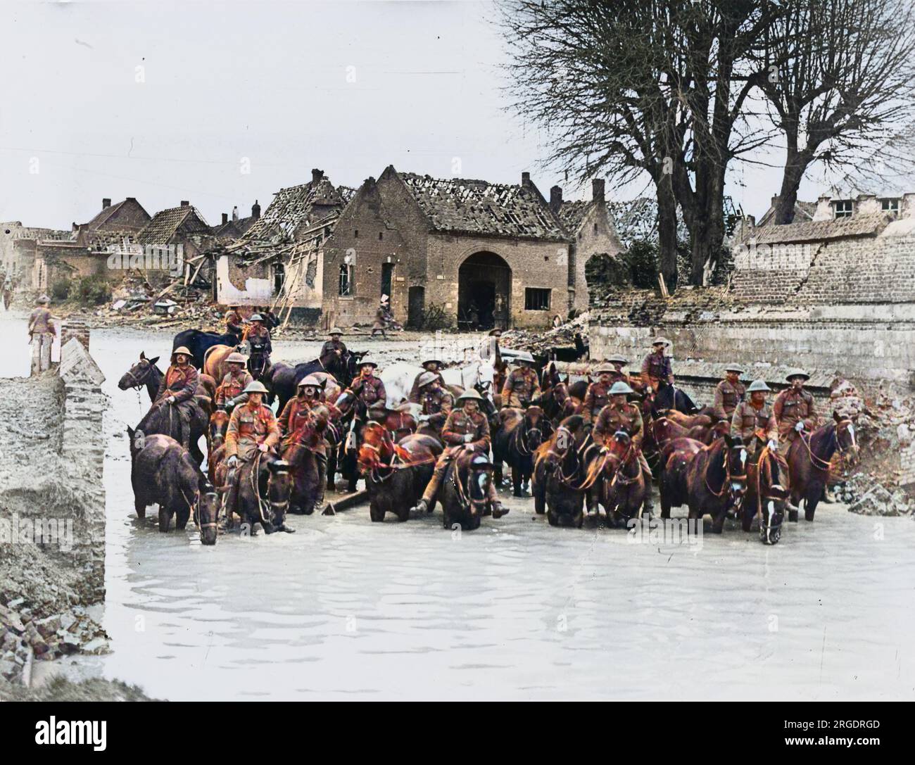 La cavalleria britannica si trovava in acqua su cavalli in una città in rovina in Francia sul fronte britannico durante la prima guerra mondiale nel 1917 Foto Stock