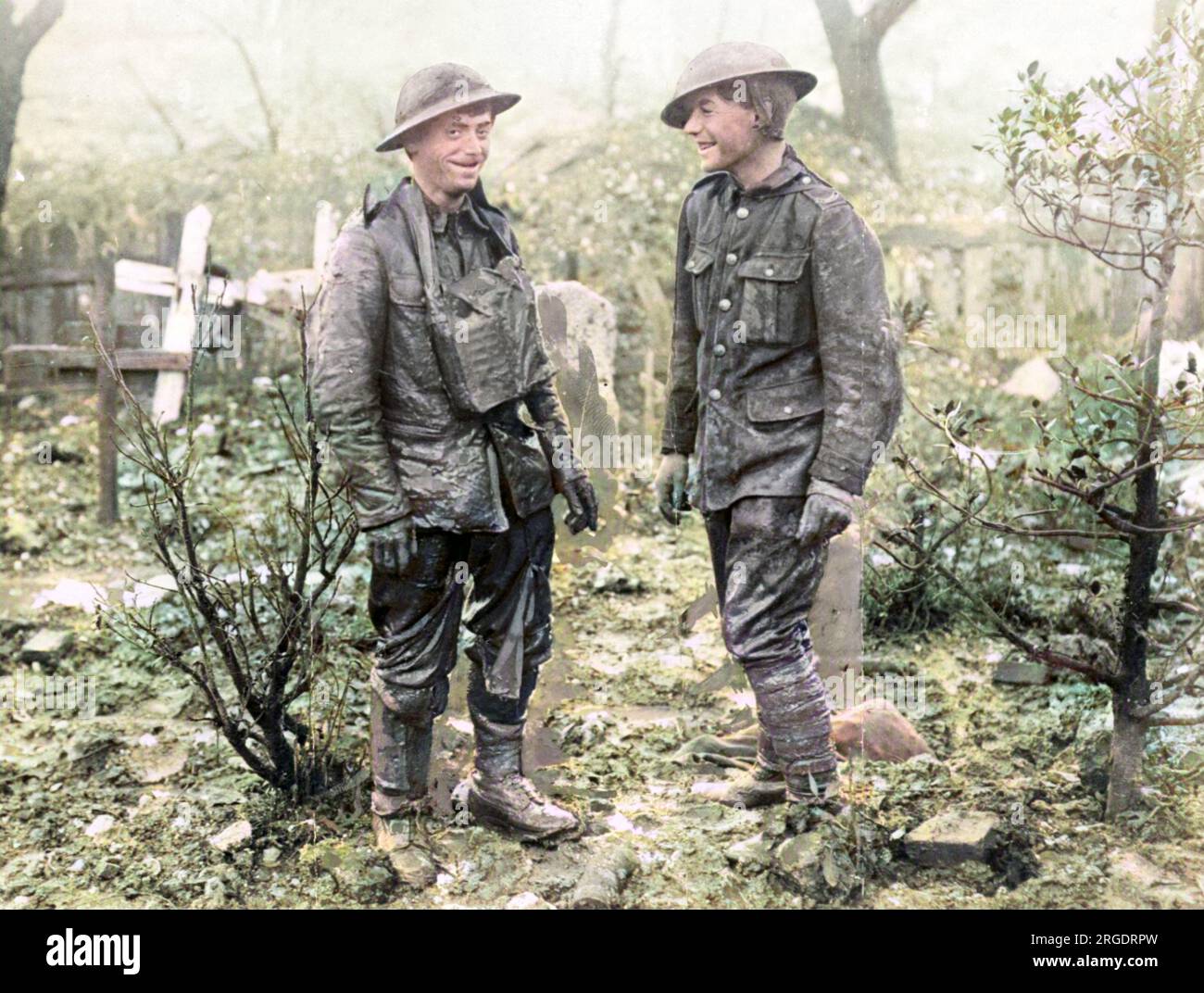 Due soldati britannici sul fronte occidentale durante la prima guerra mondiale. Le loro uniformi sono macchiate di fango, e sono in piedi in un cimitero. Foto Stock