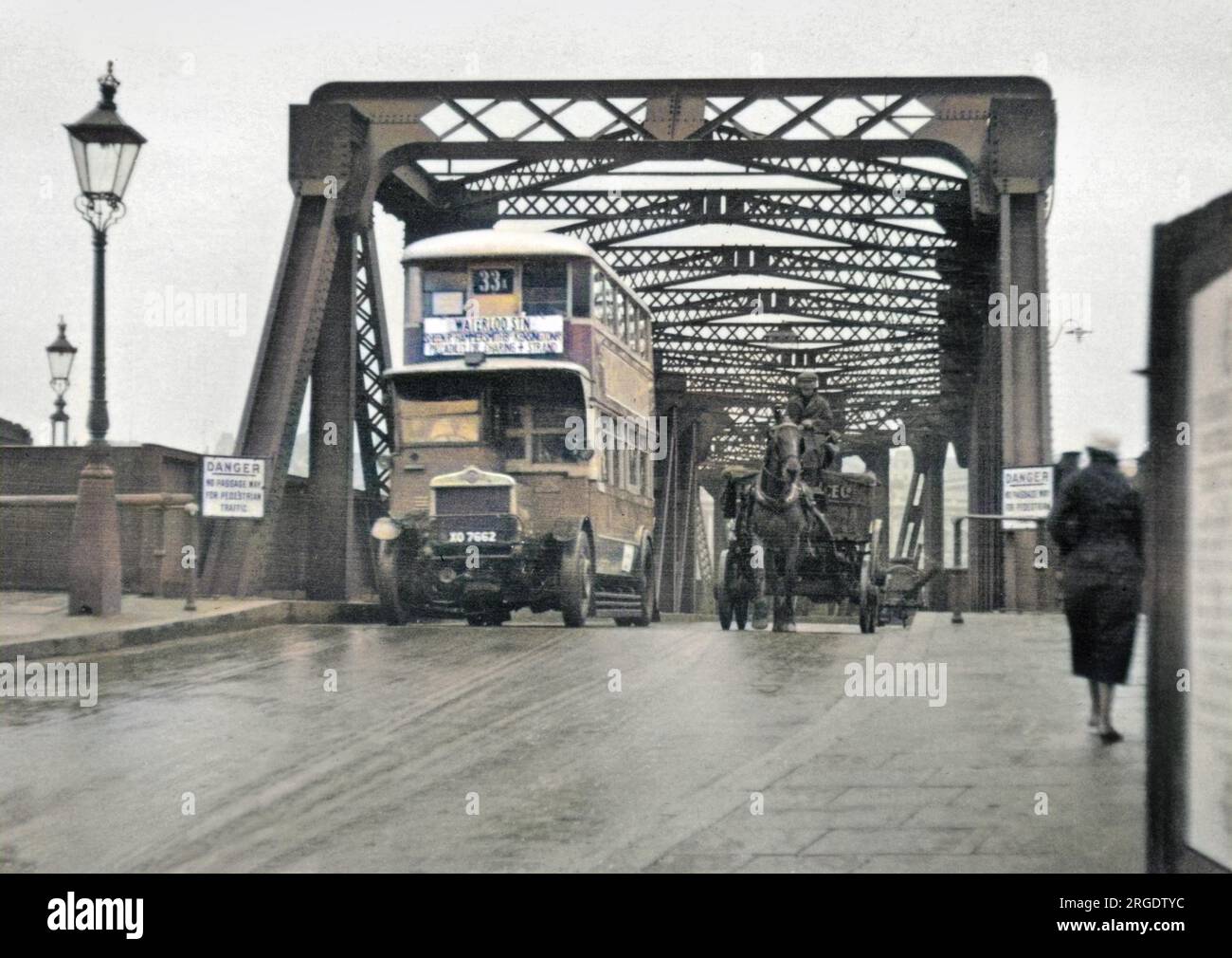 Due forme di trasporto su un ponte di Londra - un autobus a due piani sulla sinistra, un cavallo e un carrello sulla destra. L'autobus è sulla Route 33A, che serve Sheen, Hammersmith, Kensington, Piccadilly Circus, Charing Cross e The Strand. Un cartello indica: Pericolo, passaggio non previsto per il traffico pedonale. Foto Stock