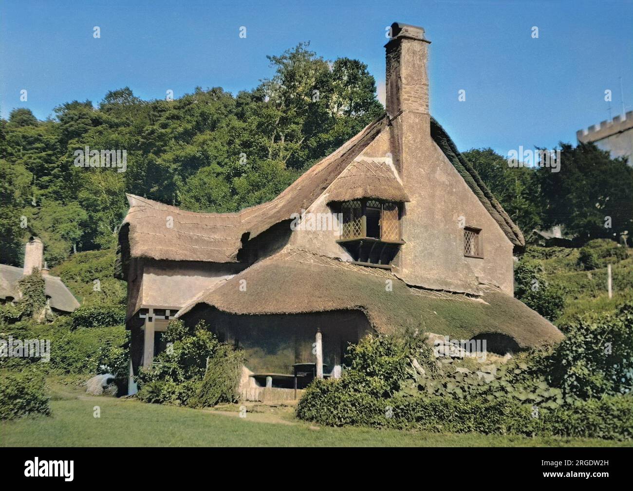 Una casa pittoresca con un tetto di paglia e una forma insolita. Foto Stock